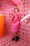 Model in candy factory wearing pink outfit with sexy rose faux latex half long skirt 