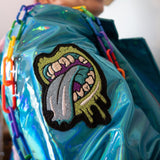 blue punk biker jacket made of iridescent shiny synthetic fabric with hot pink zippers rainbow chain and patches zombi  mouth right side view