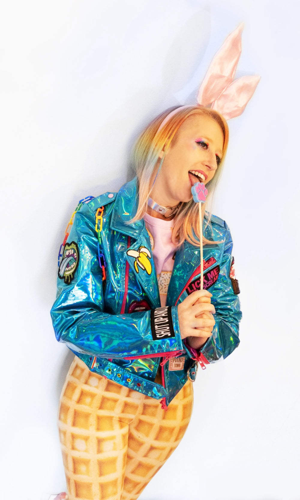 blue punk biker jacket made of iridescent shiny vinyl fabric material with hot pink zippers rainbow chain and patches sweet but twisted front view