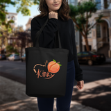 model holding up black cotton tote bag with orange peach and whip and text kinky in San Francisco