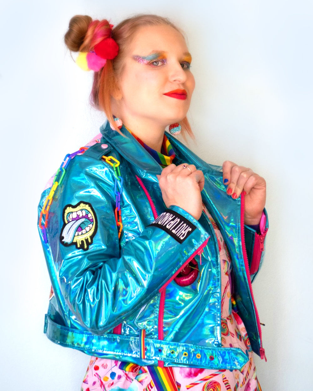 blue punk biker jacket made of iridescent shiny synthetic fabric with hot pink zippers rainbow chain and patches sweet but twisted side view for LGBTQ kink fashion